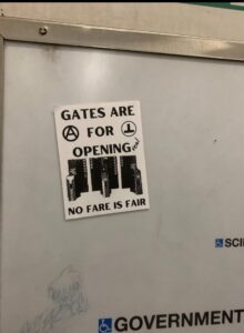 Sticker that reads "Gates are for Opening. No Fare is Fair." Written on it in marker is the word "real"